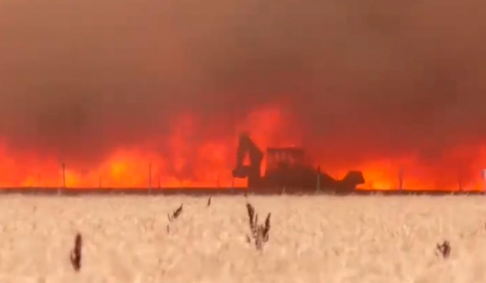 男子开挖掘机挖沟挡山火 衣服被烧光